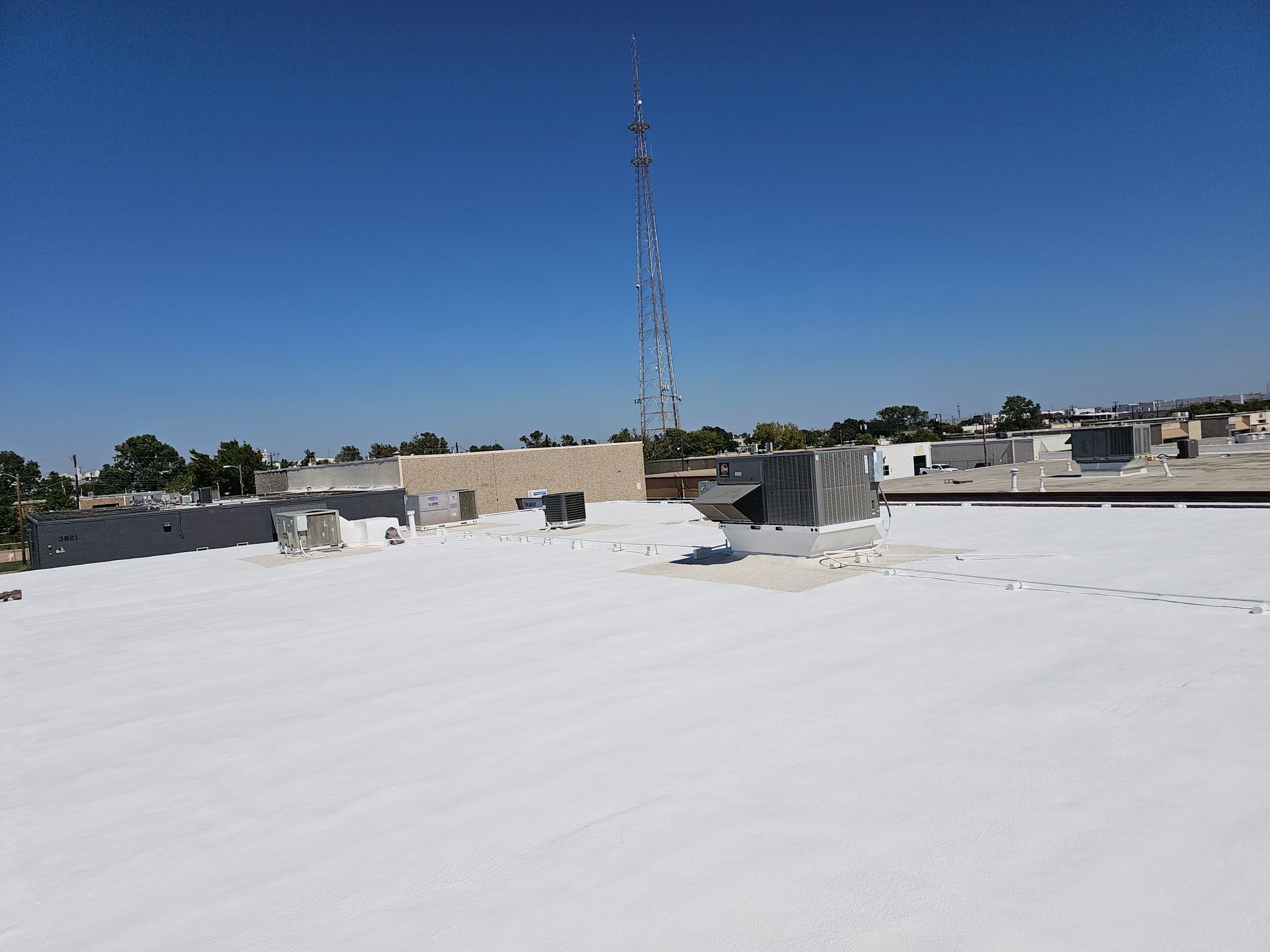 A large white roof with a tower in the background.