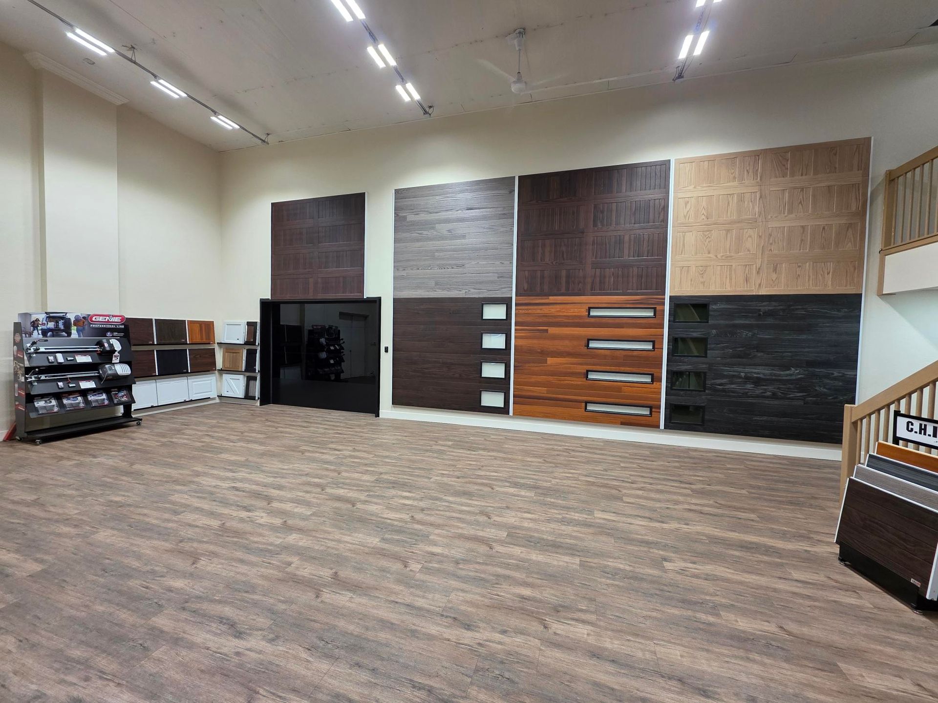 Showroom with wood panel samples on wall, carpeted floor, and various door displays.