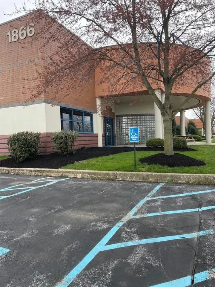 Building with a brick facade and accessible parking space. Address 