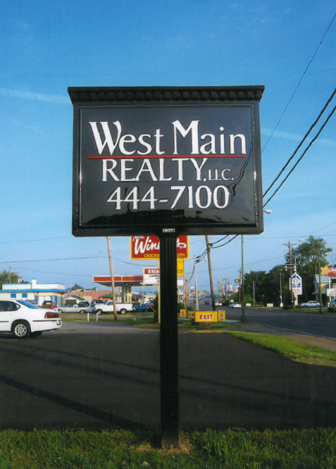 A sign for west main realty shows the phone number 444-7100
