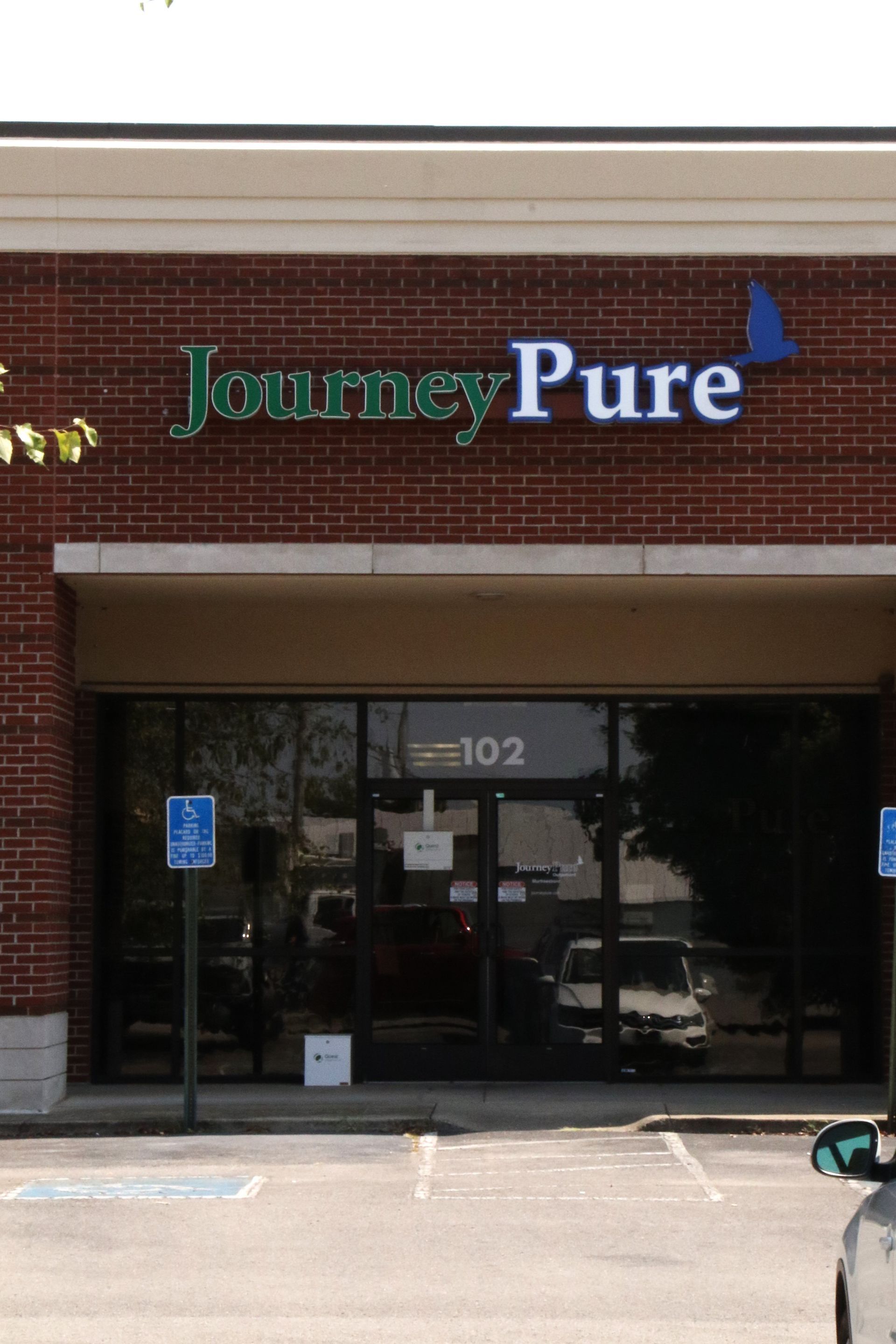 A car is parked in front of a journey pure store