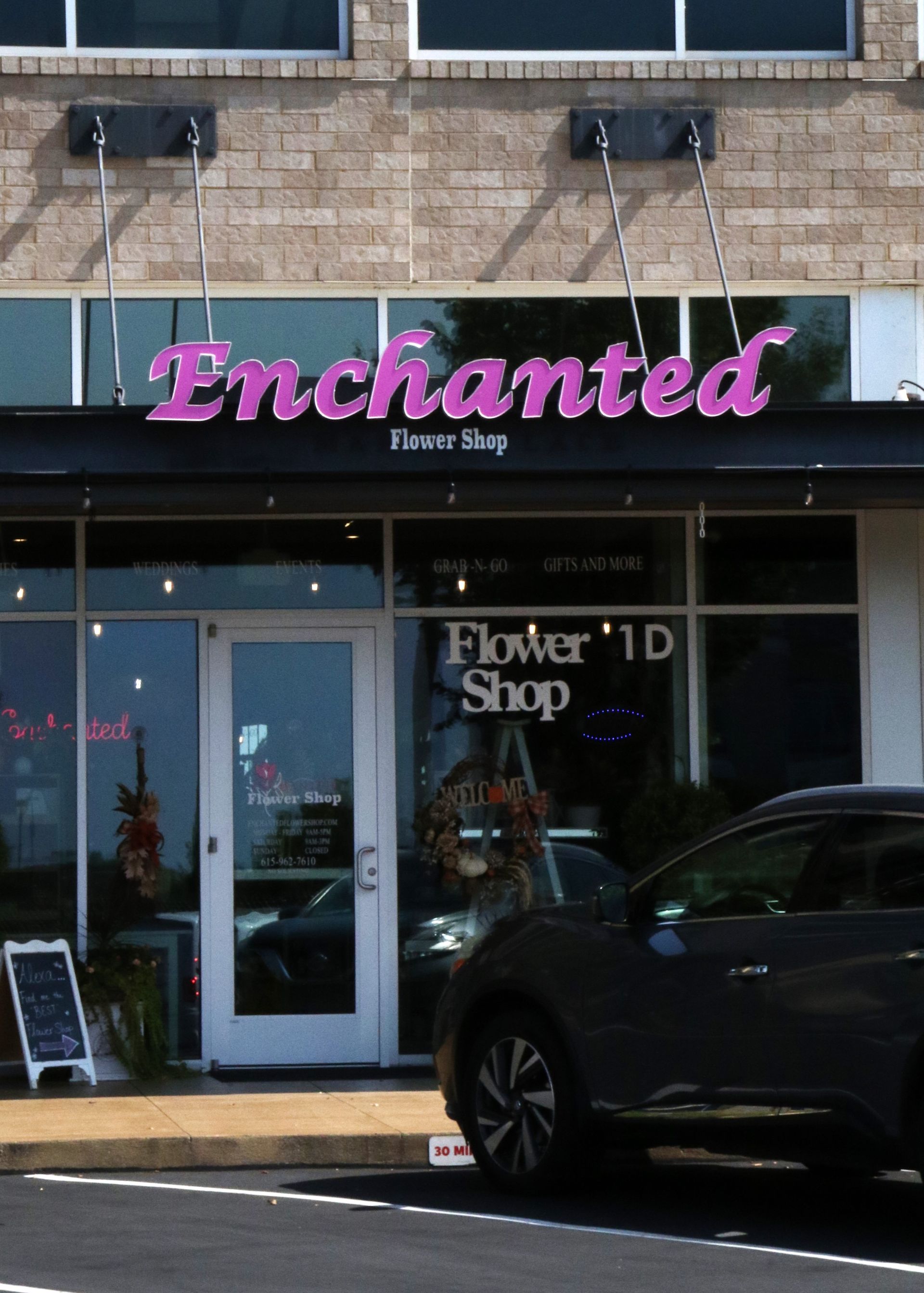A car is parked in front of the enchanted flower shop