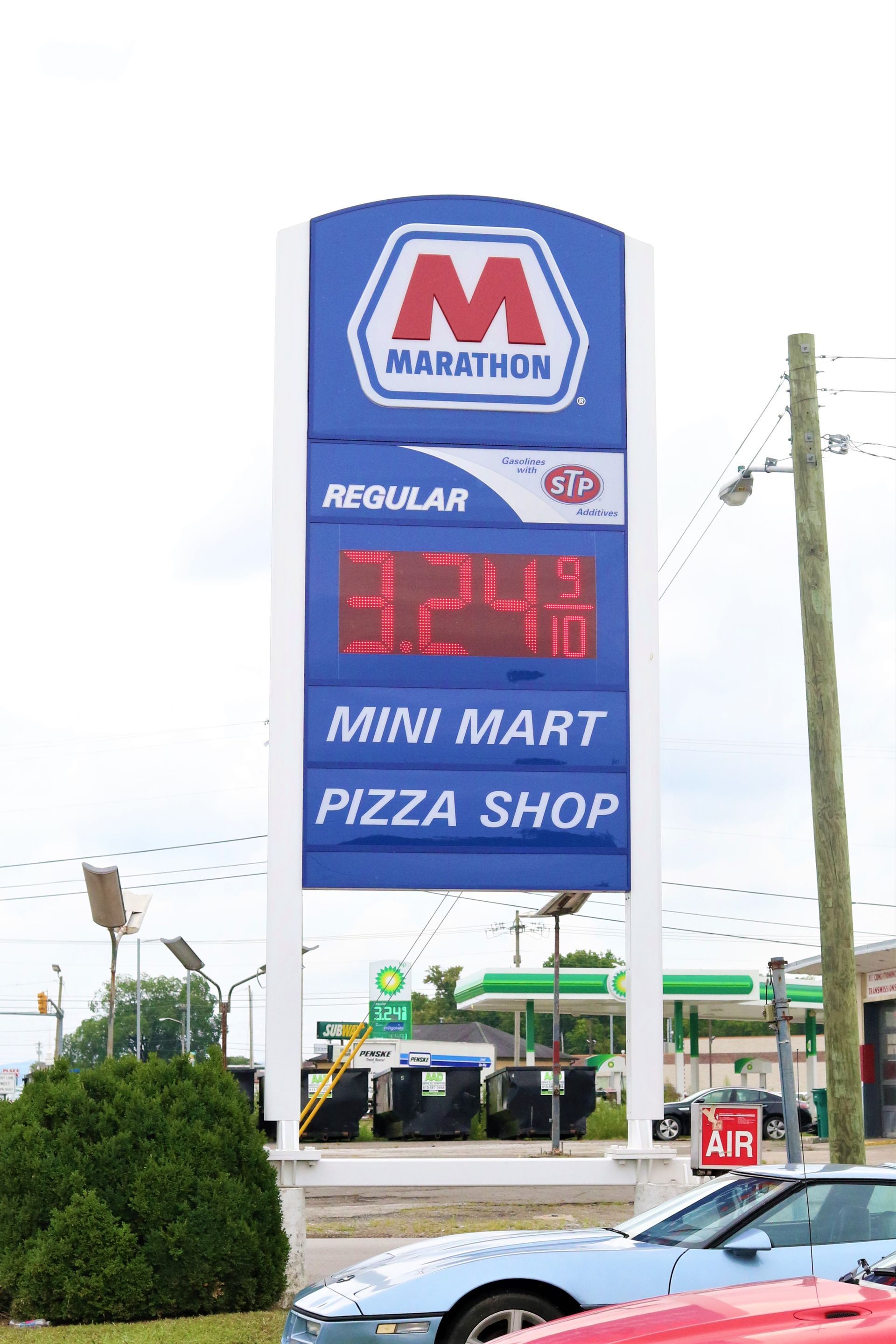 A gas station with a sign that says `` regular '' and `` mini mart ''.