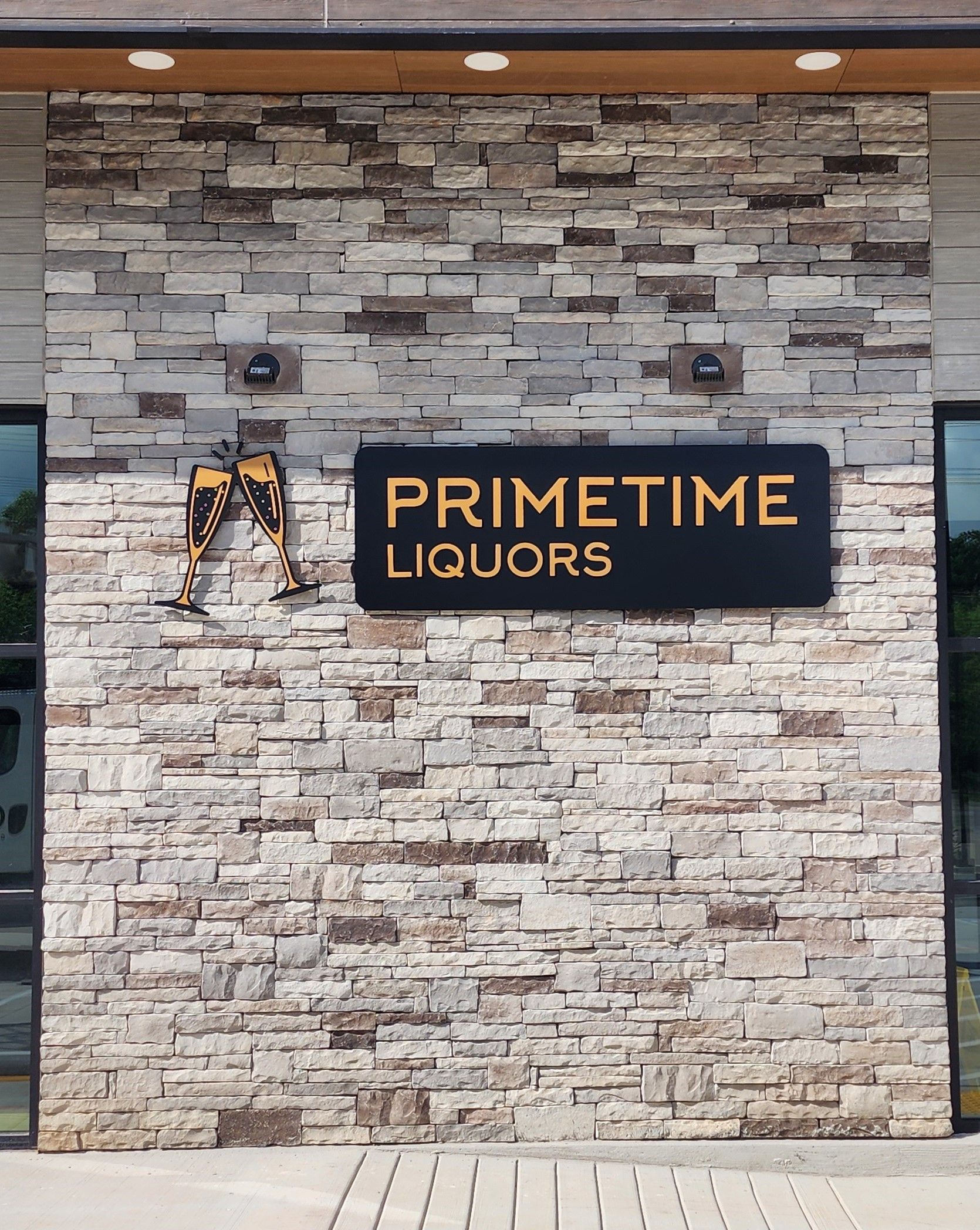 A brick wall with a sign that says primetime liquors