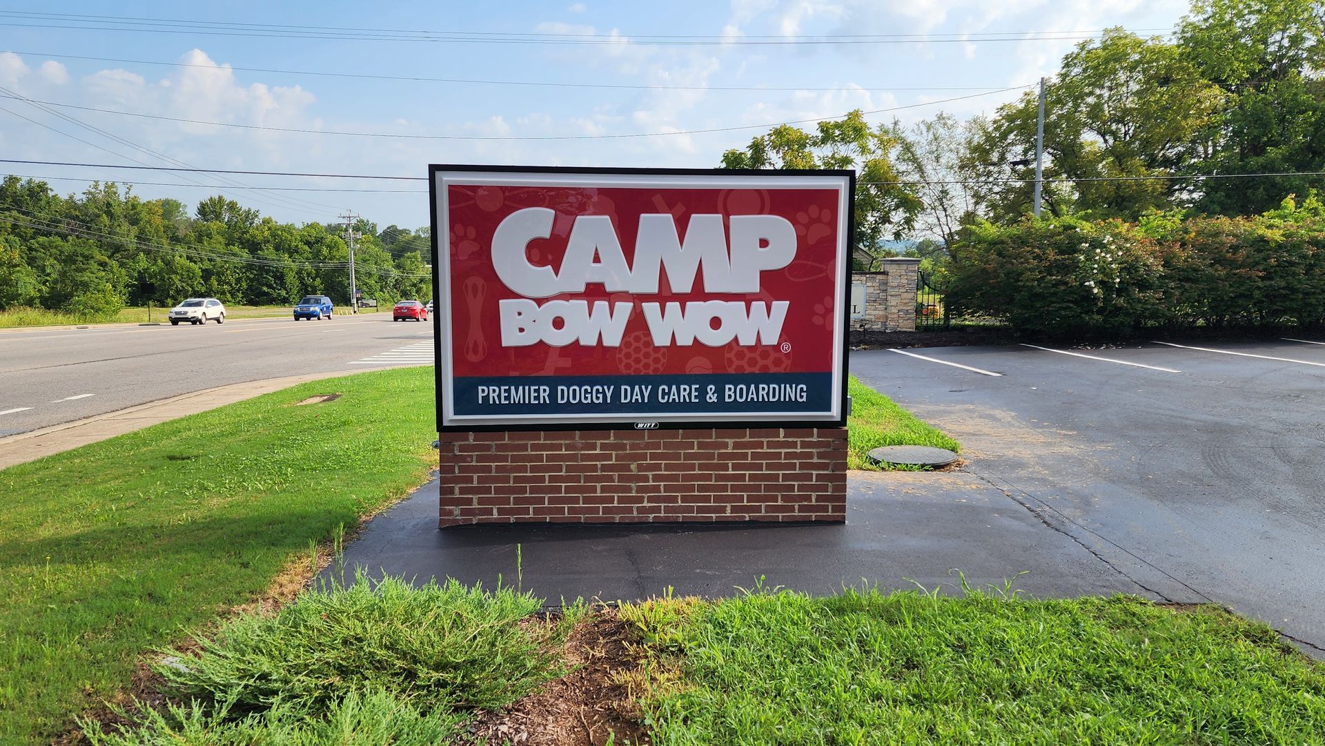 A red and white sign that says camp bow wow on it