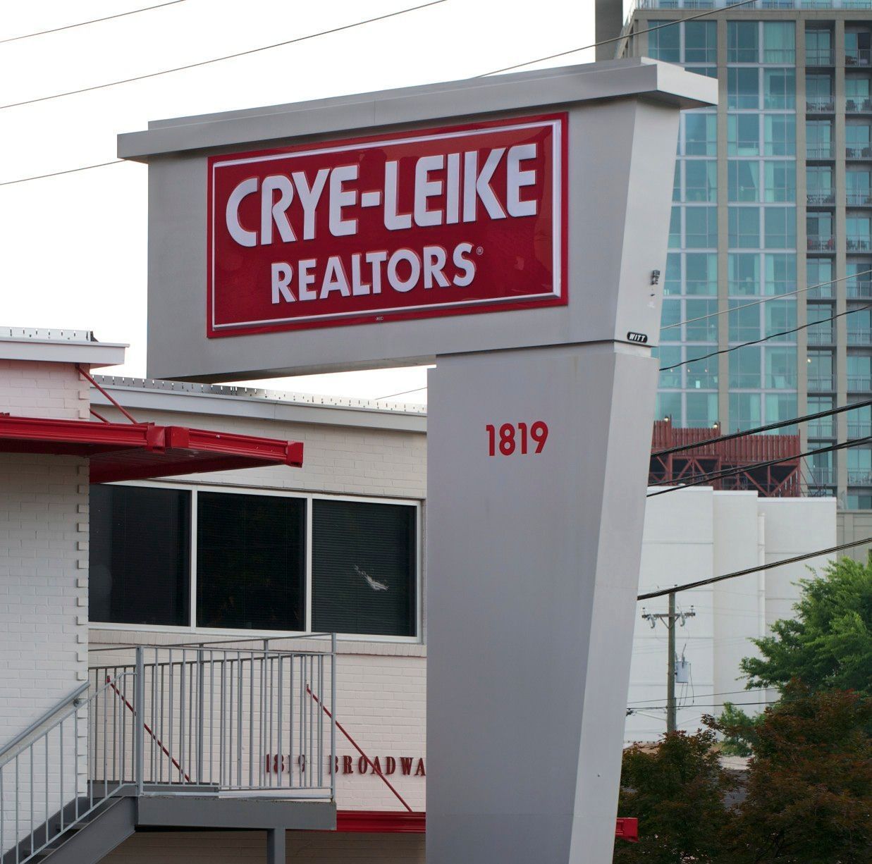 A sign for crye-leike realtors is above a building