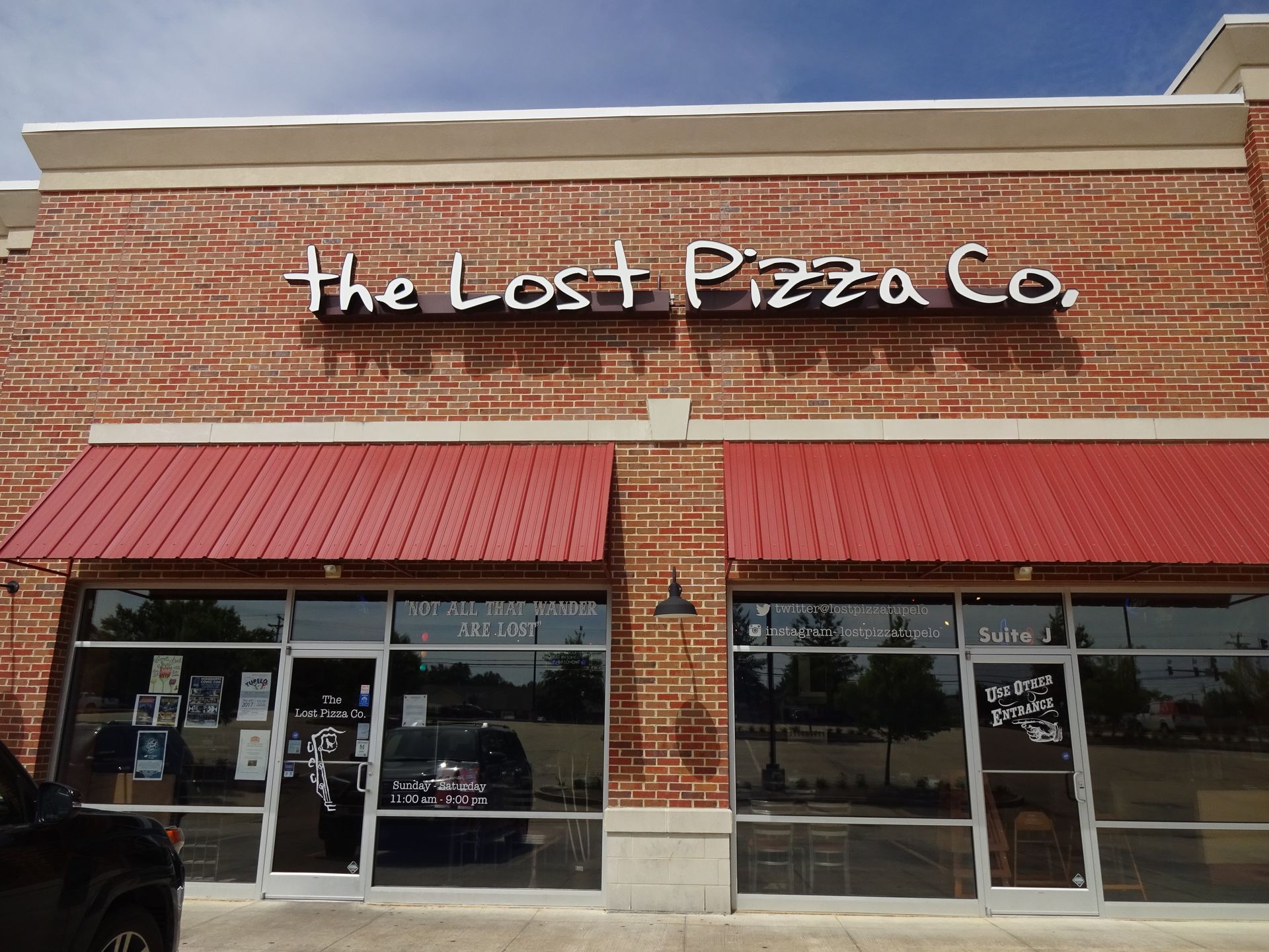 A brick building with a sign that says the lost pizza co.