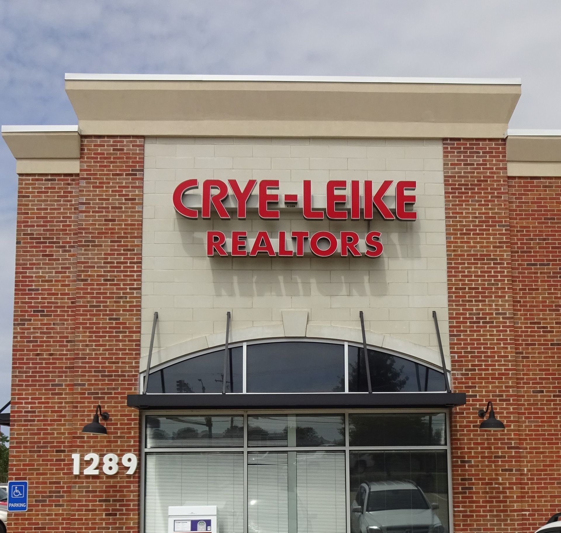 A brick building with a red sign that says crye-leike realtors