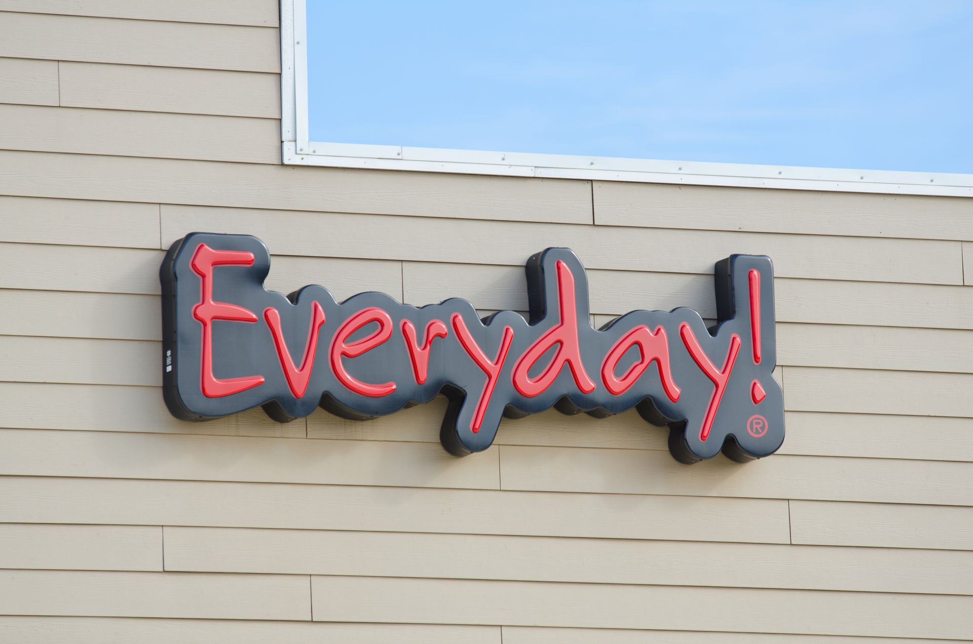 A sign on the side of a building that says everyday