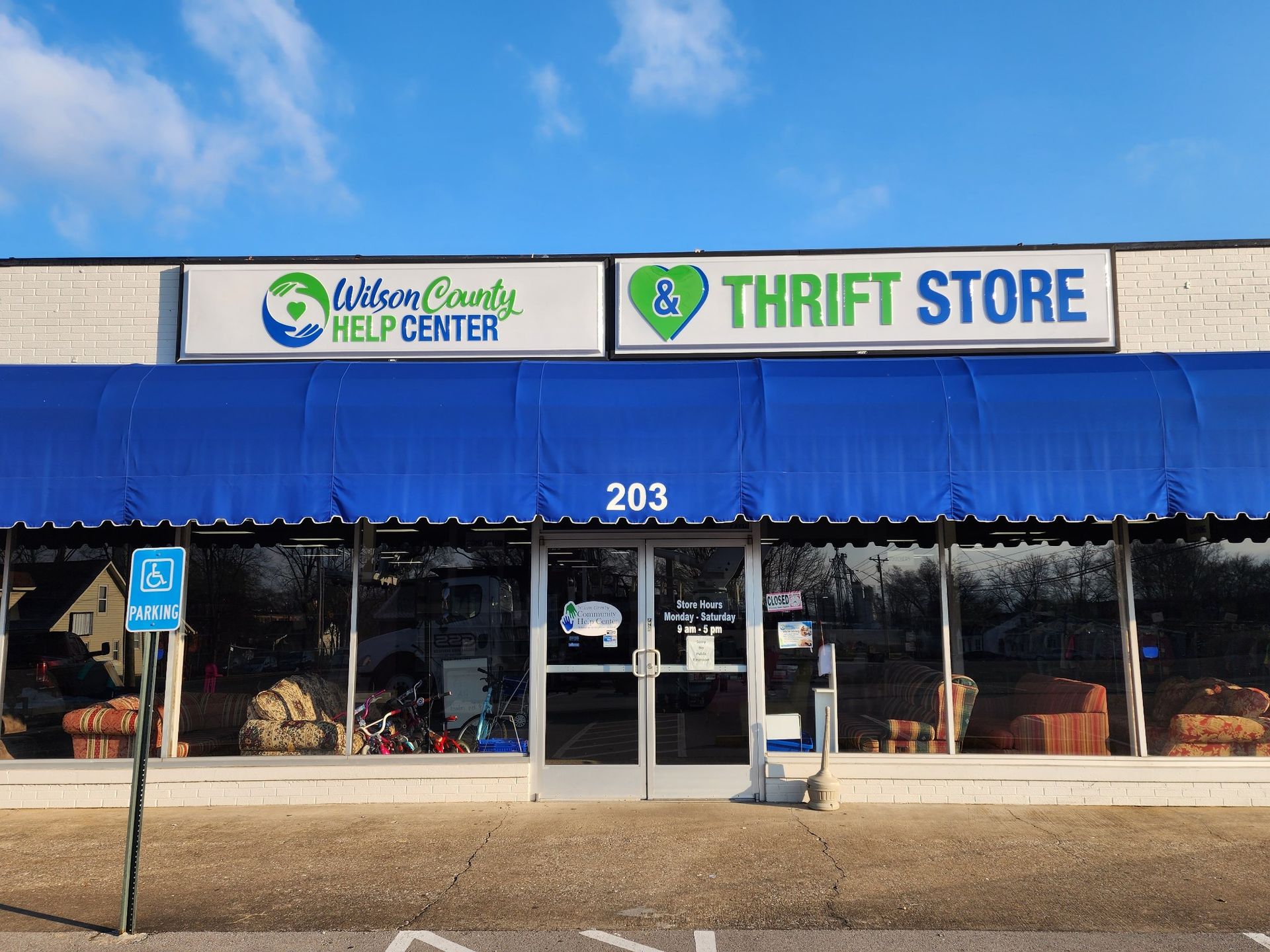 The front of a thrift store with a blue awning.
