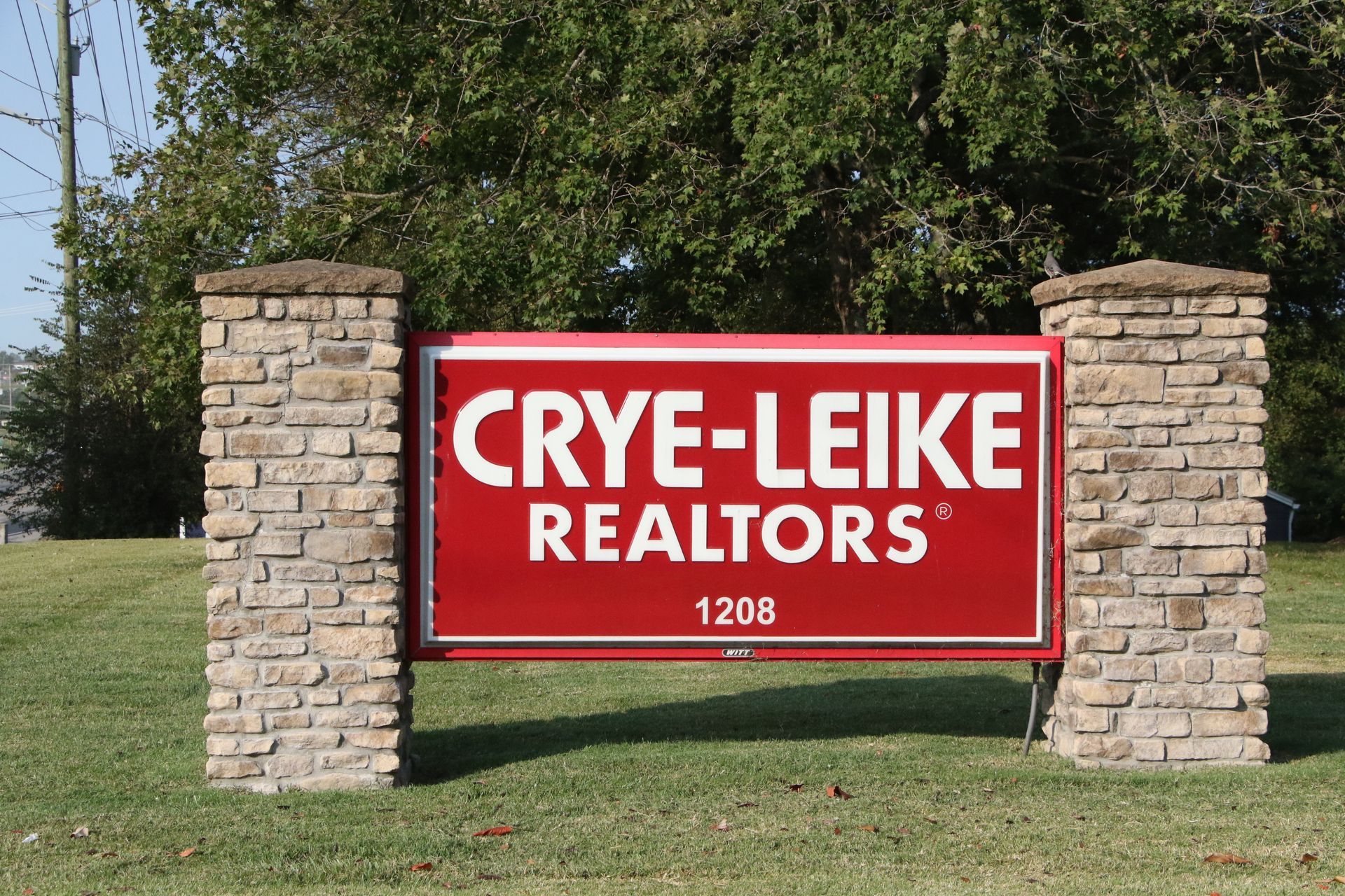 A red sign that says crye-leike realtors on it