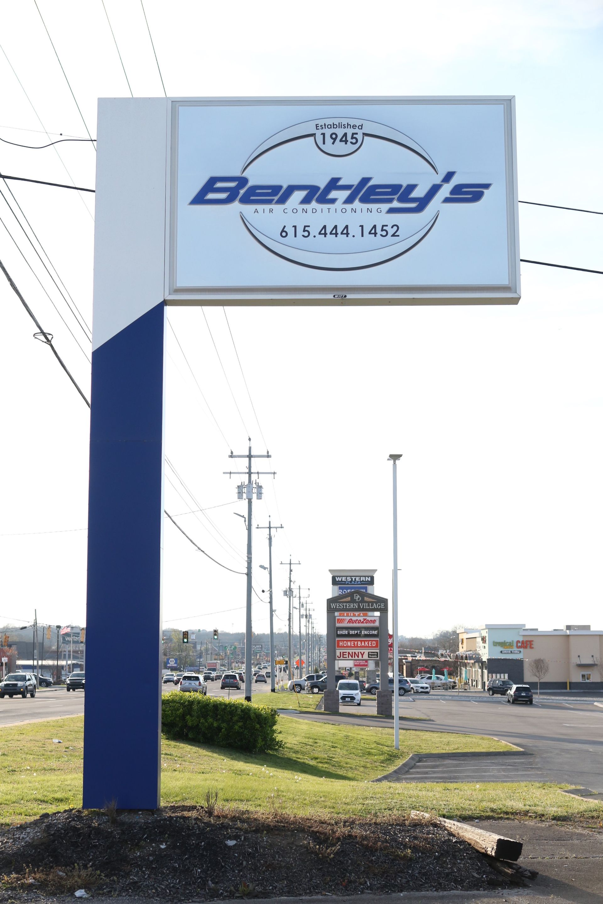 A bentley 's sign is sitting on the side of a road