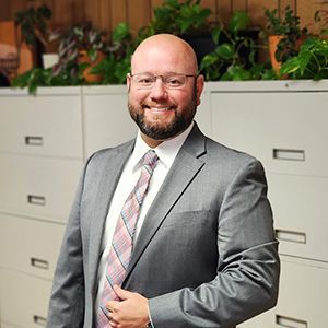 A man in a suit and tie is smiling for the camera.