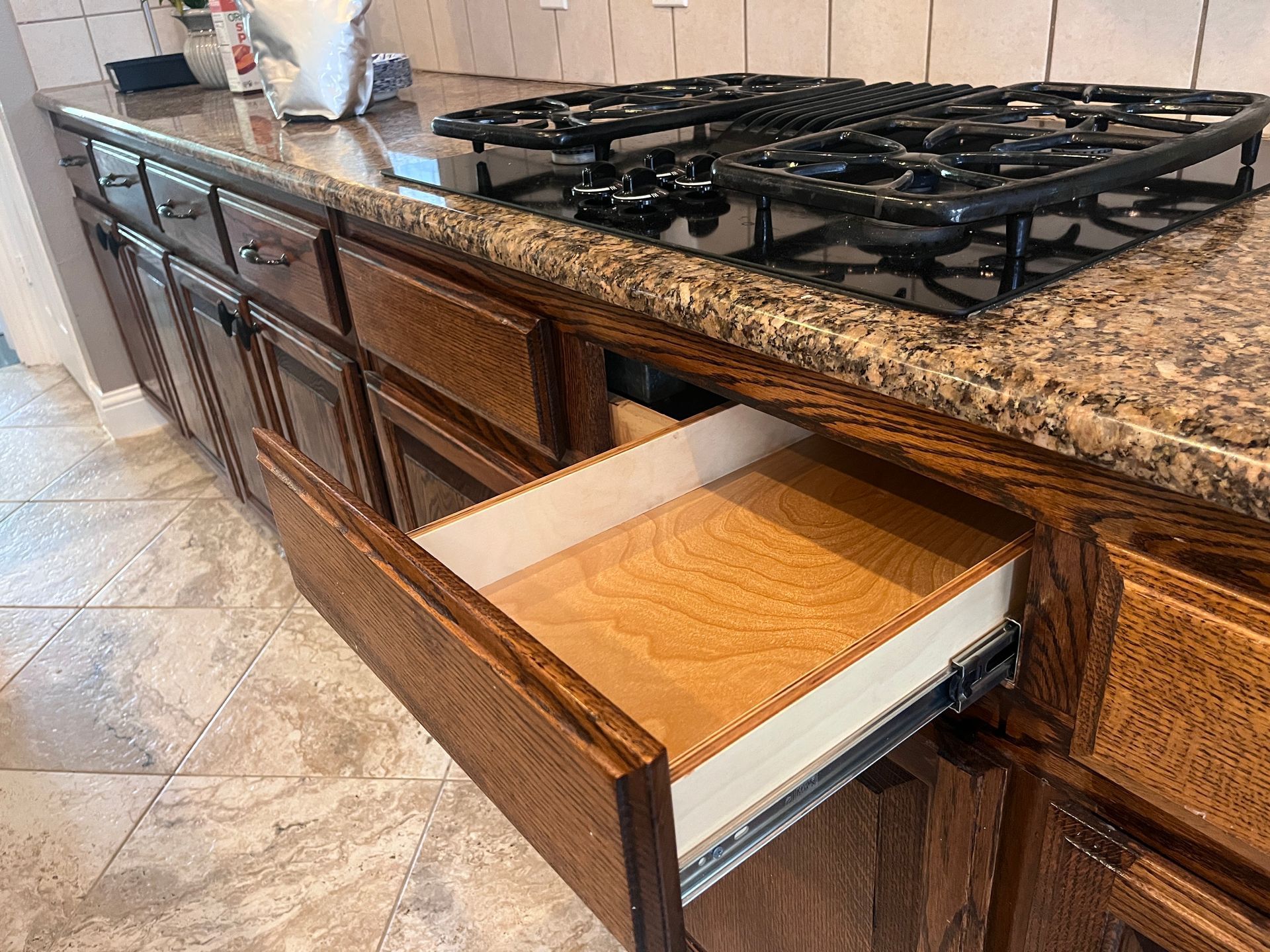 Custom soft-close pull out shelf under a cooktop receiving a warranty adjustment two years after ins