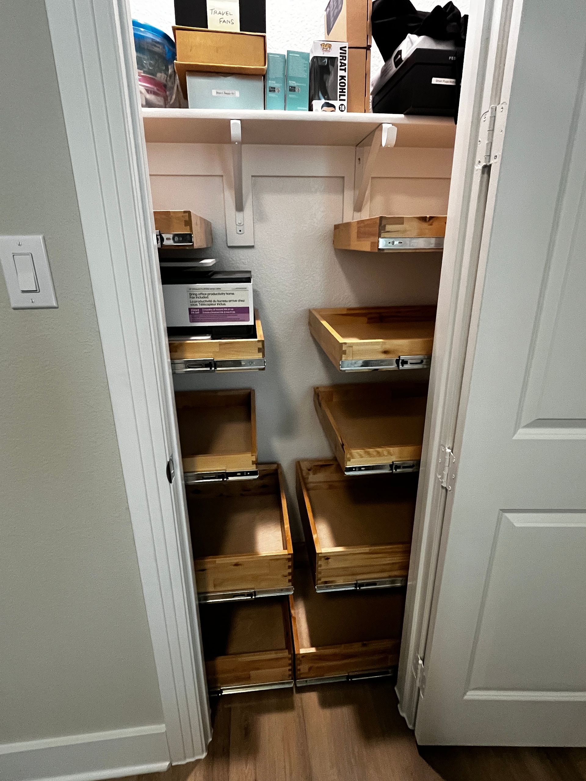 Custom pull-out shelves in a Melissa, TX closet organize a home office with accessible storage for a