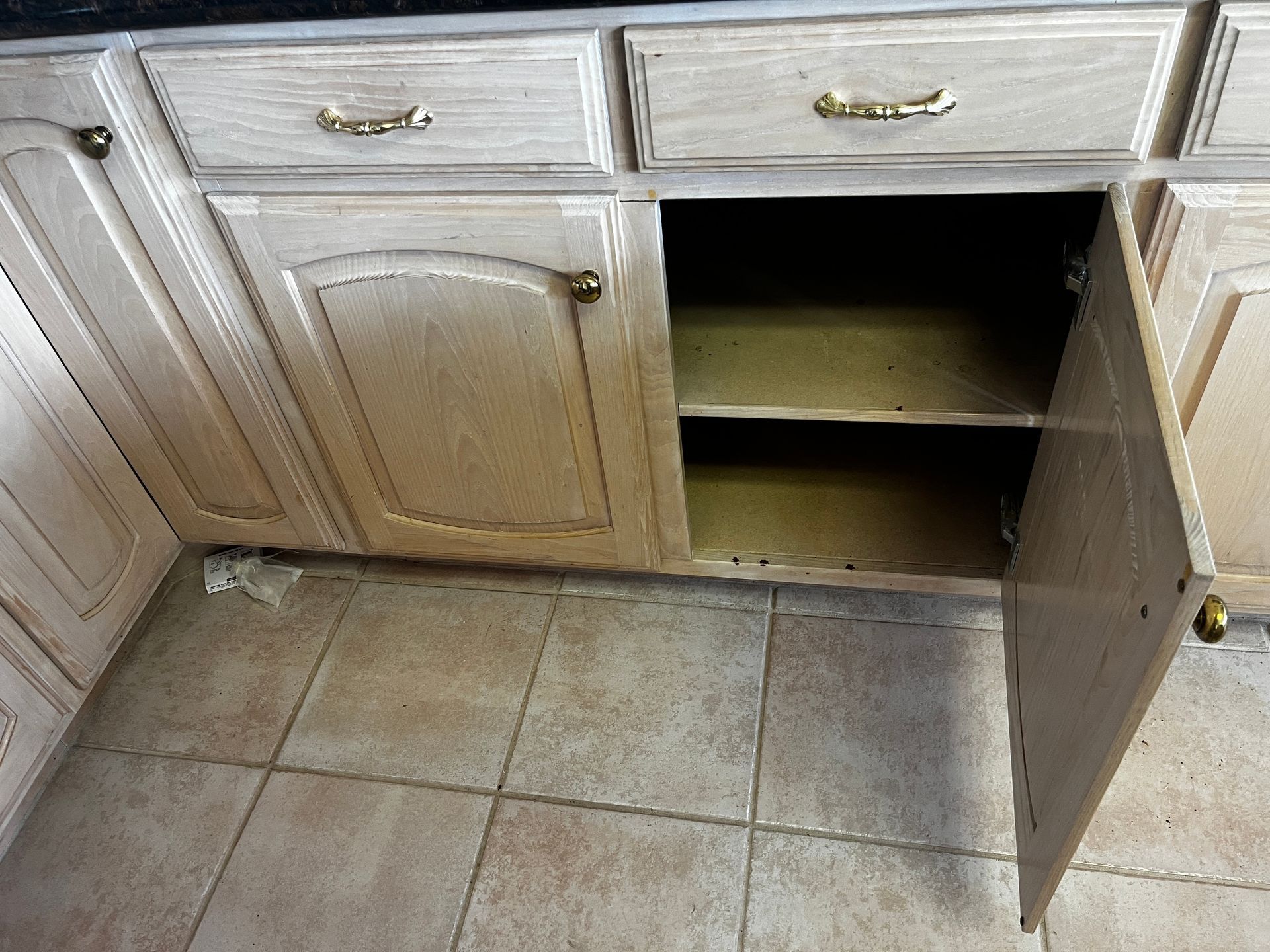 Before photo of a kitchen base cabinet in Coppell, TX, showing the original cabinet opening before center stile removal and installation of custom pullout shelves.
