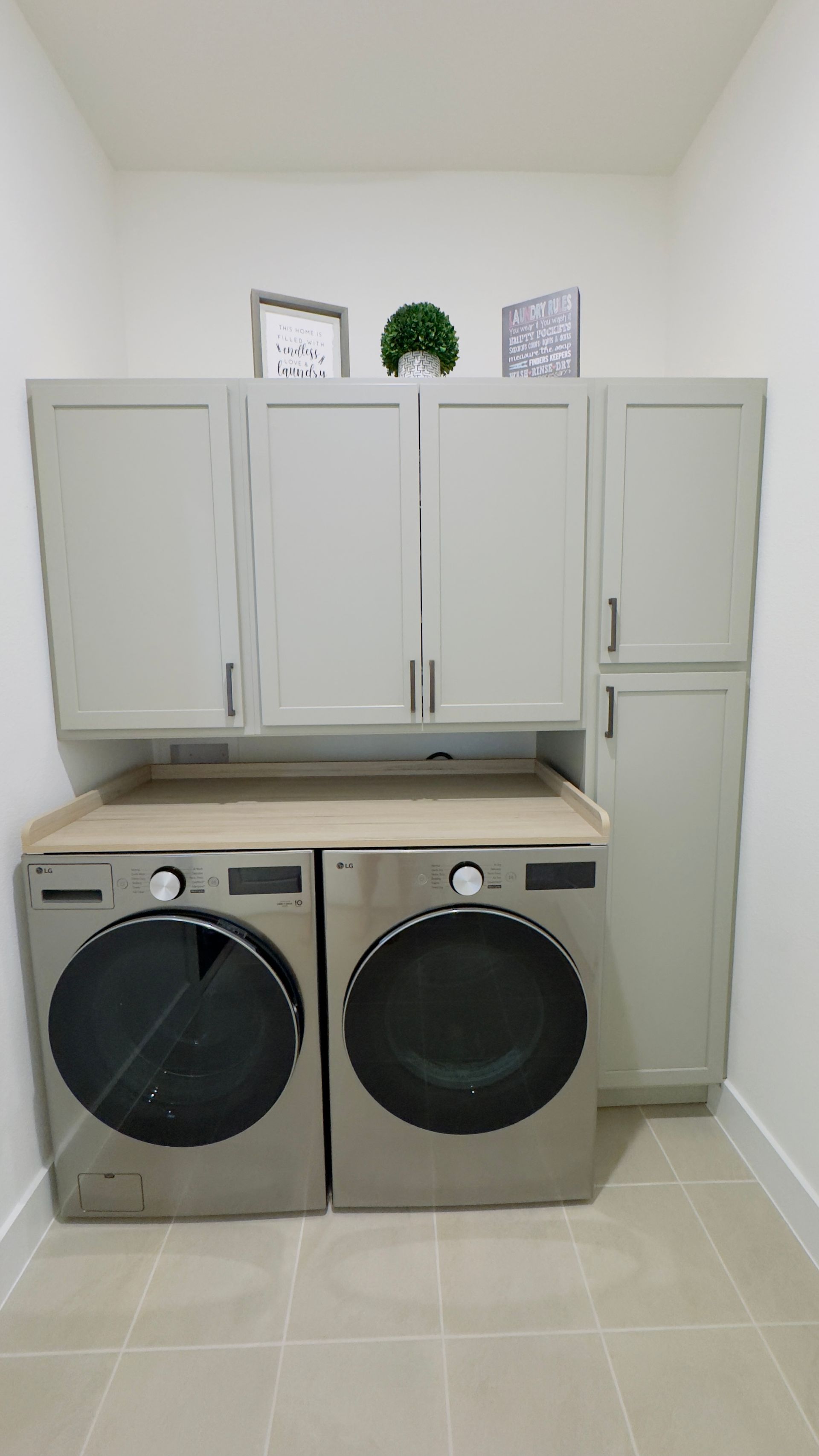 Laundry room cabinets in The Colony, TX above washer and dryer with  tall storage.