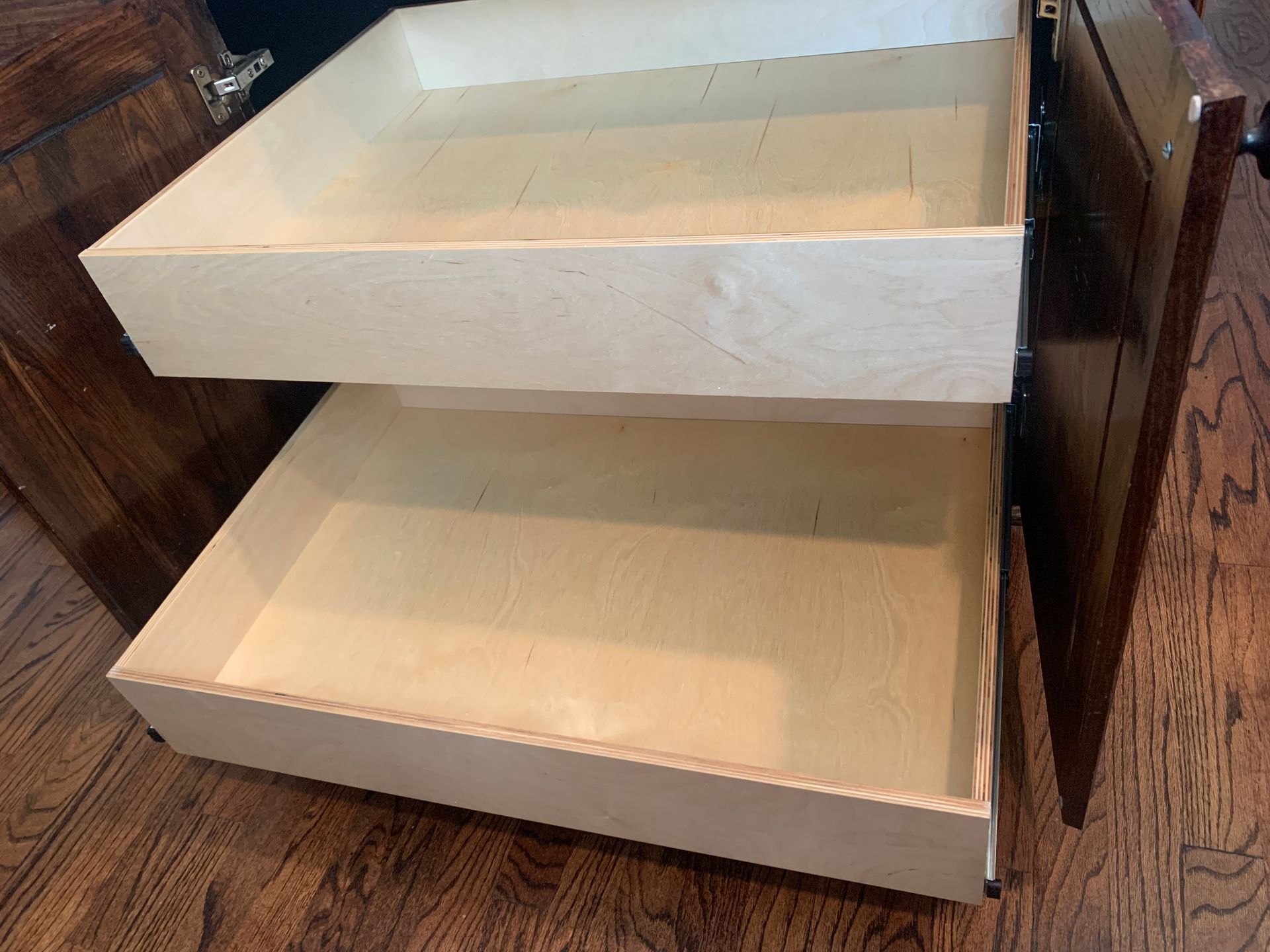 Open wooden drawers inside a dark brown cabinet.