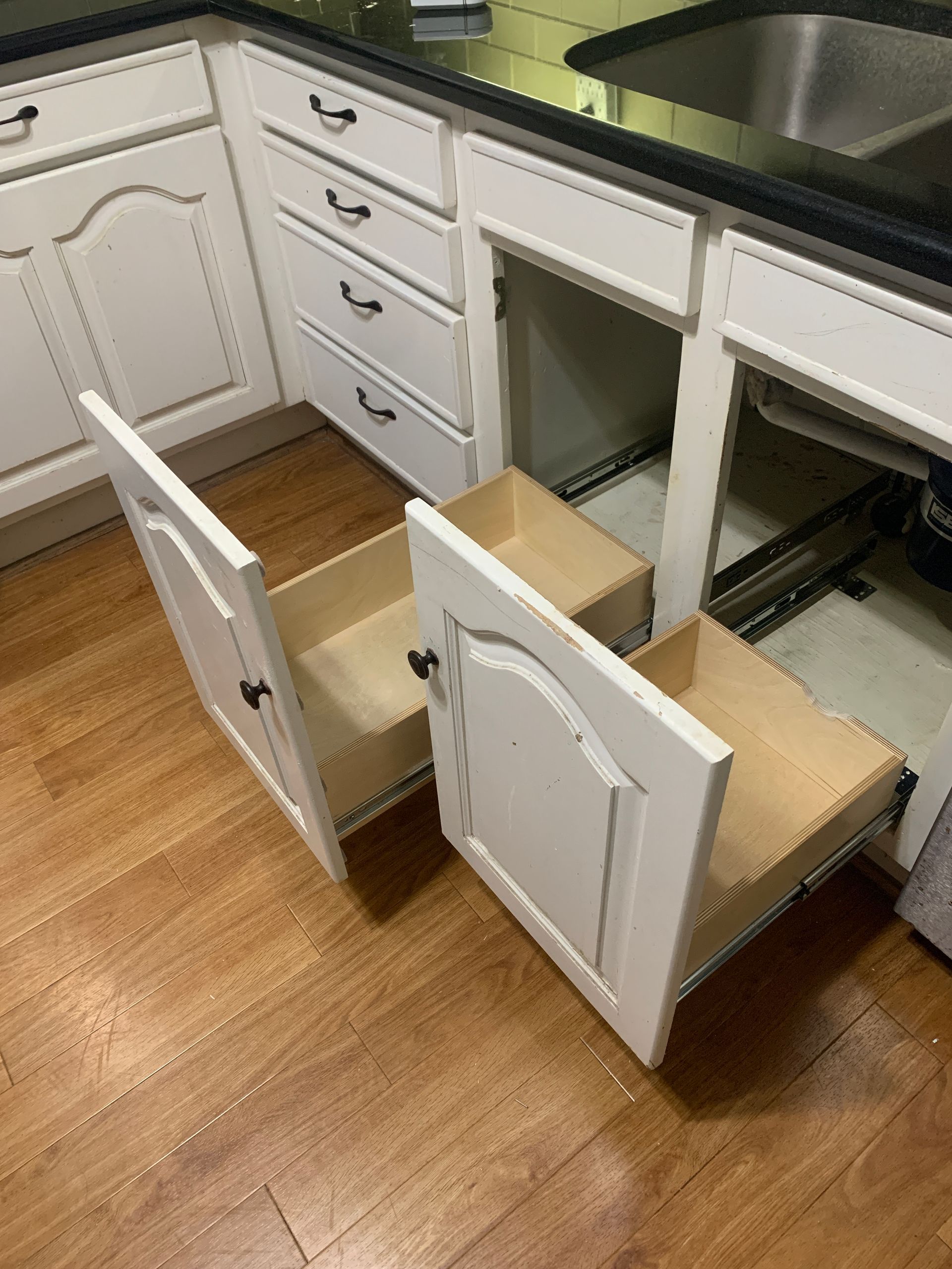 Kitchen cabinets with open drawers, showing construction and drawer slides.