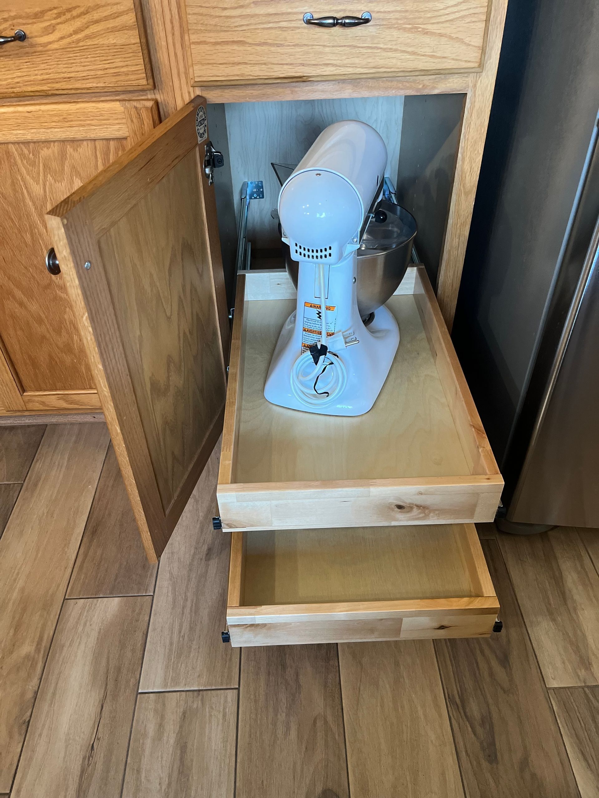 Stand mixer on an upper custom pull-out shelf beneath an existing cabinet drawer in a Dallas, TX kitchen.