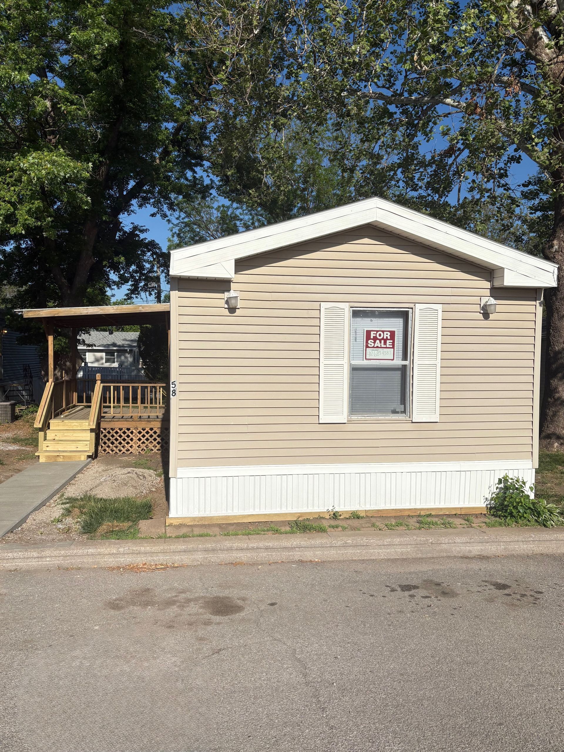 A mobile home with a sign on the window that says `` for sale ''.