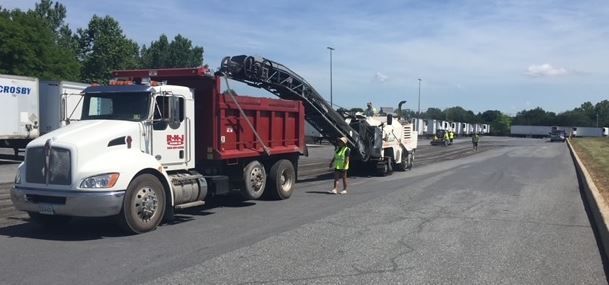 A dump truck is sitting on the side of a road.