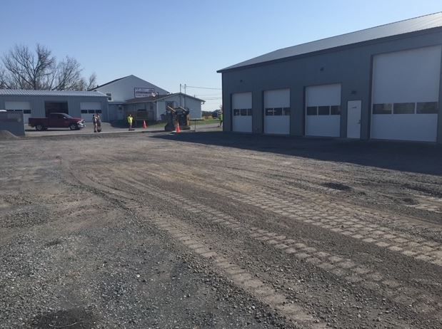 A truck is parked in a parking lot in front of a garage.