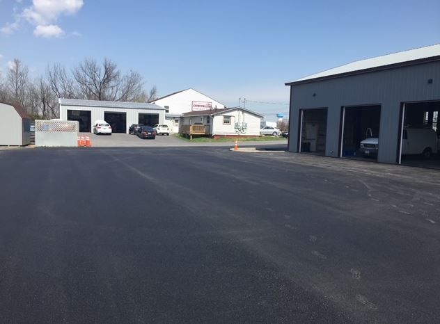 A garage with a lot of cars parked in front of it
