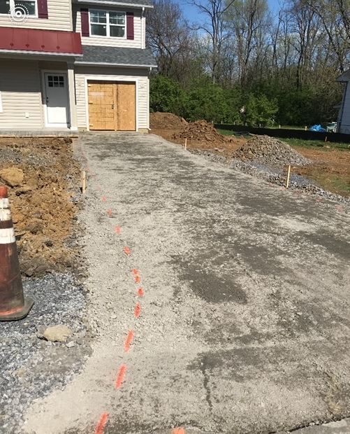 A concrete driveway is being built in front of a house