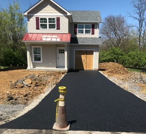 A caution tape cone sits in front of a house