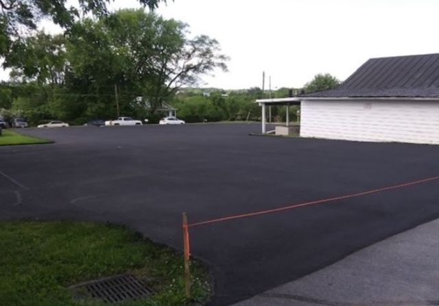 A large parking lot with a white building in the background.