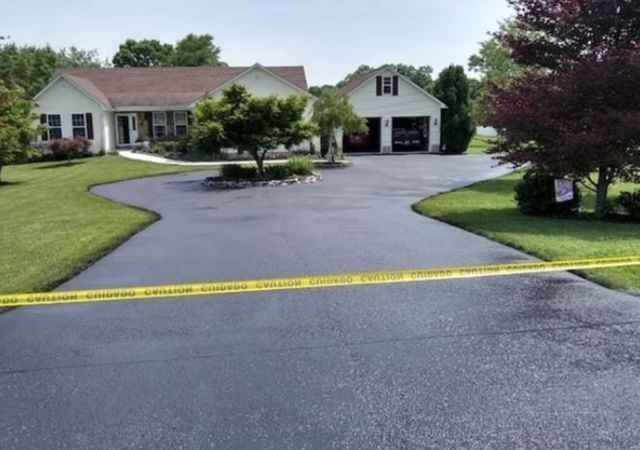 A driveway leading to a house with a yellow tape on it