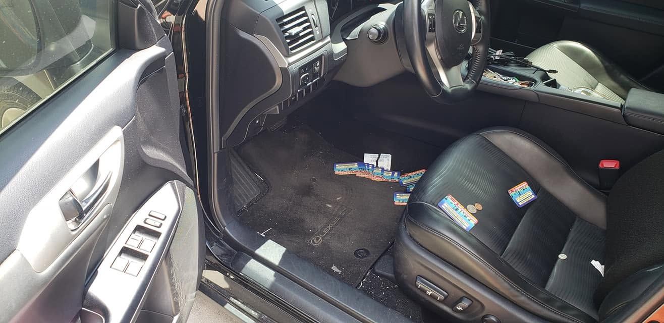 Car interior with front seats and floor littered with trash and debris