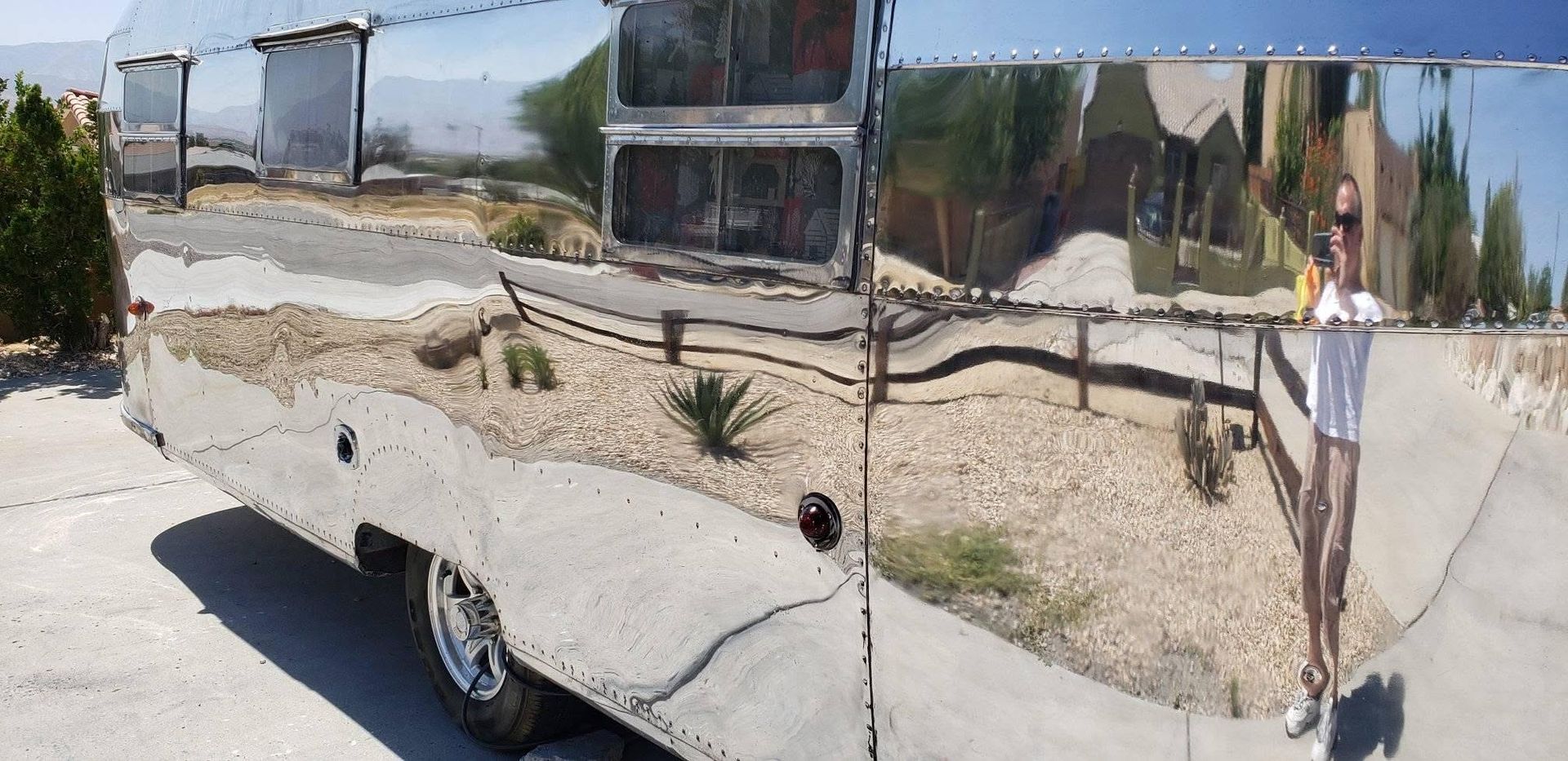 Shiny silver trailer with chrome panels parked on a sunny street