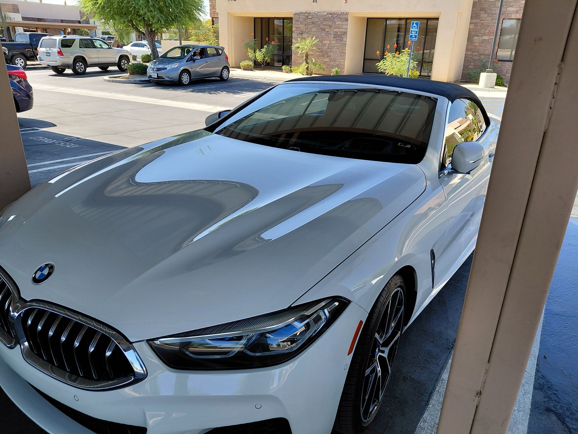 White BMW coupe parked under a covered outdoor area