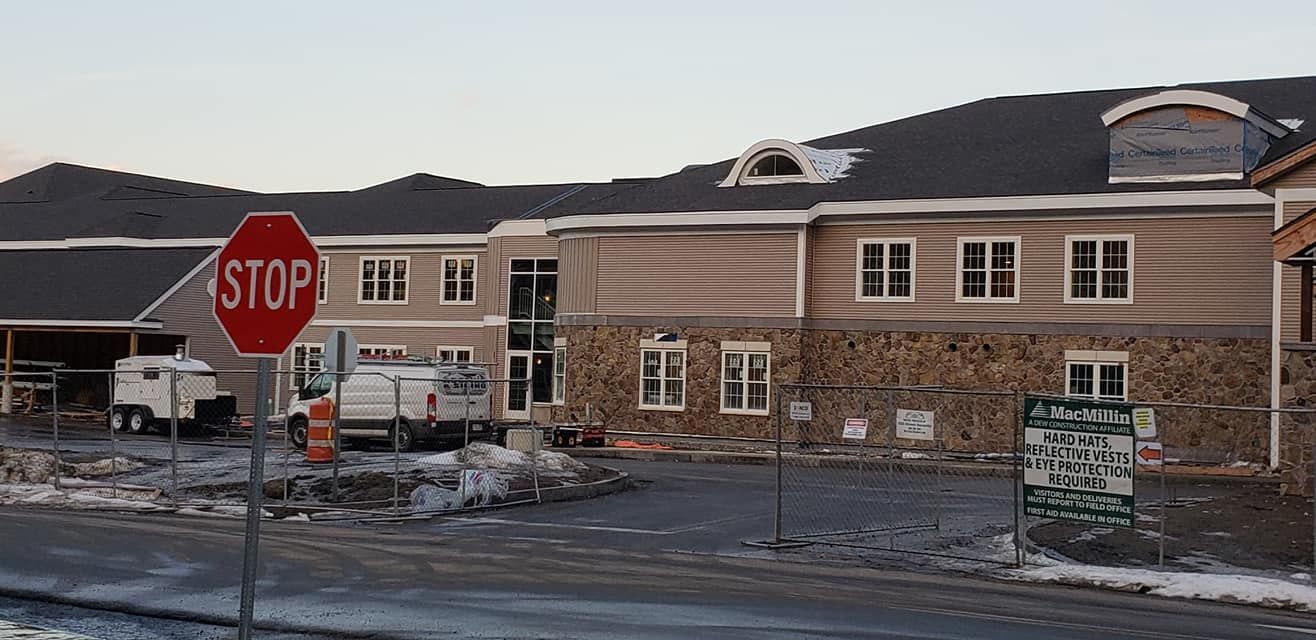 A stop sign is in front of a building under construction.