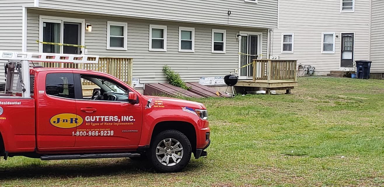 A red truck is parked in front of a house.