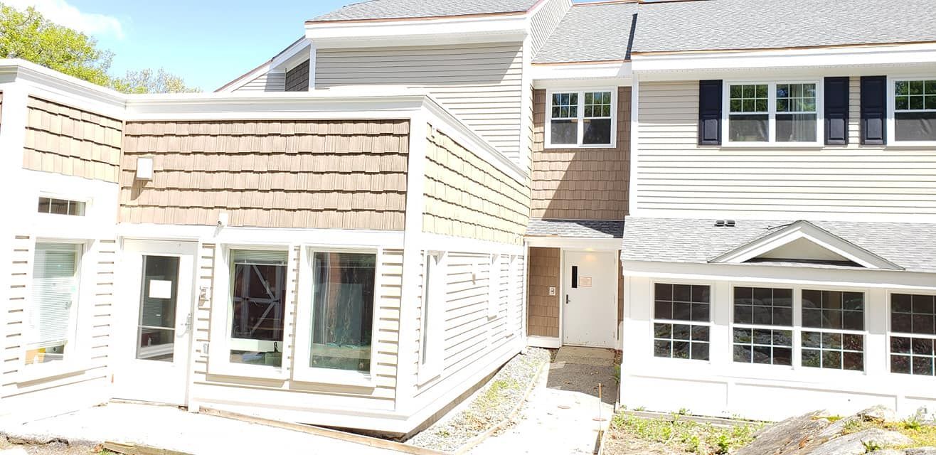 A large white house with a lot of windows and a roof.