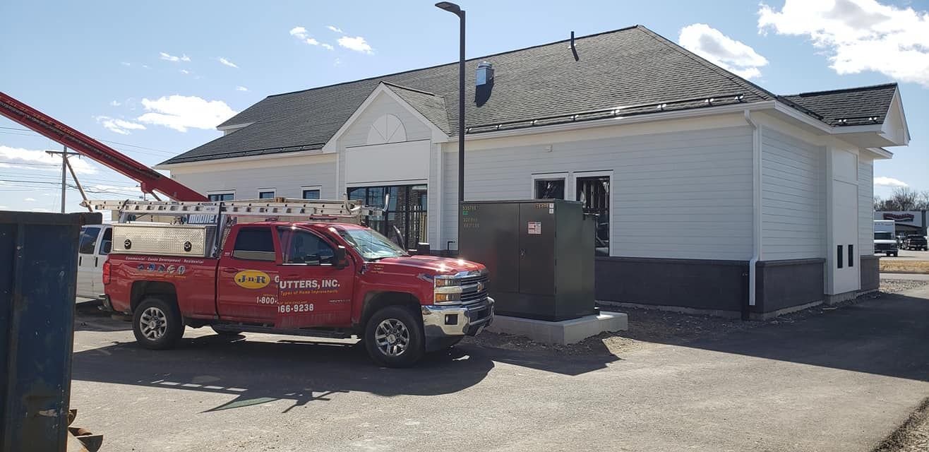 A red truck is parked in front of a building.