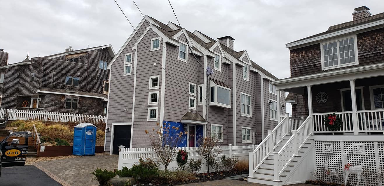 A row of houses with a blue portable toilet in front of them.
