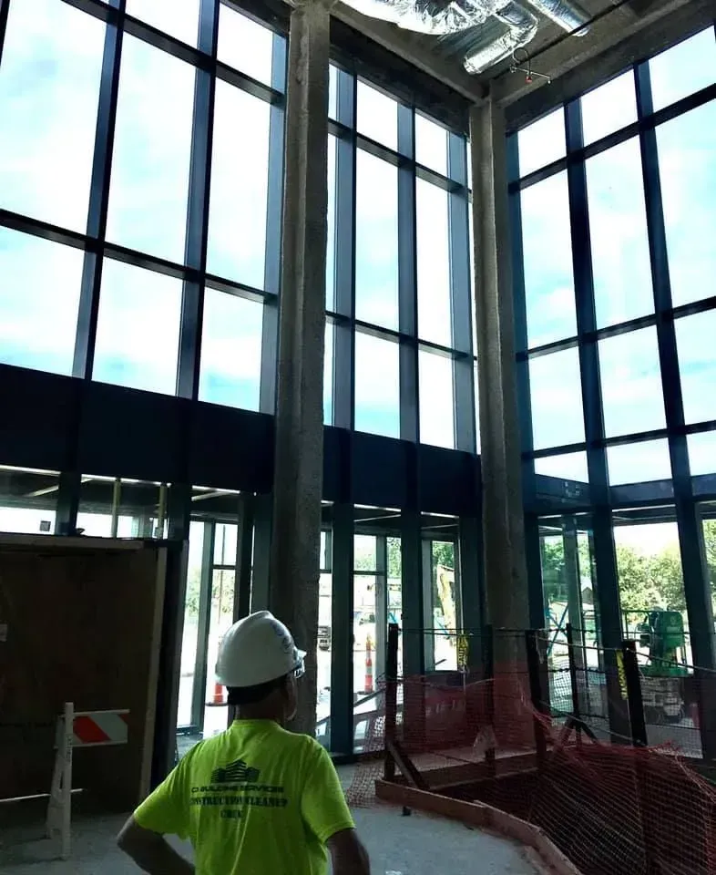 Worker in hard hat inside a modern glass atrium under construction