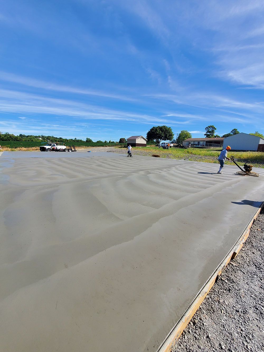 Flooded beach with rippling muddy water, blue sky, and people in the distance