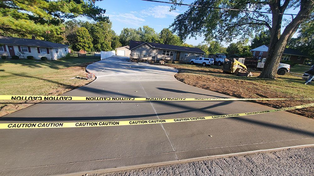 Police tape blocks a quiet residential street near houses and trees.