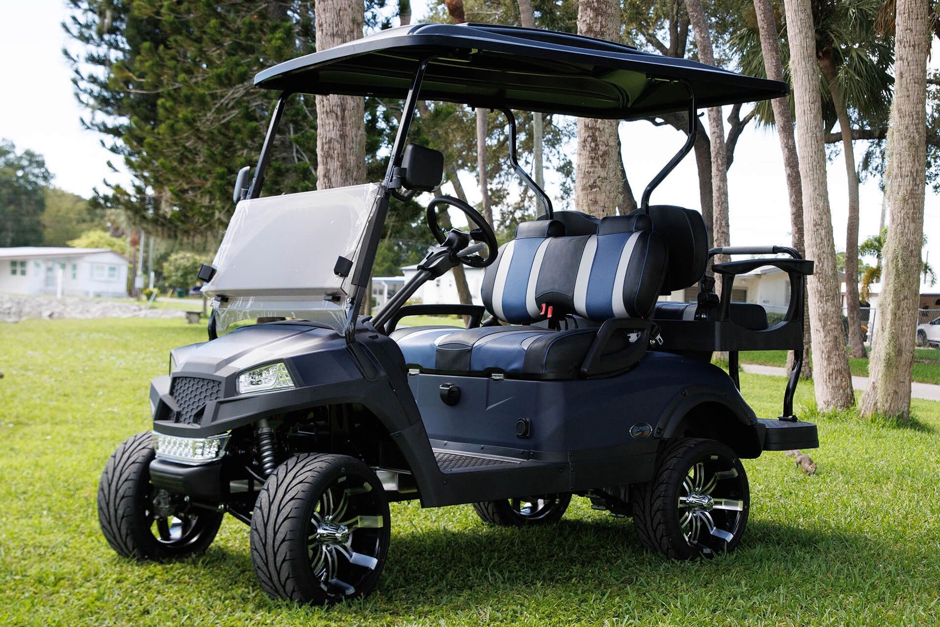 Dark blue golf cart with black accents, parked on grass.