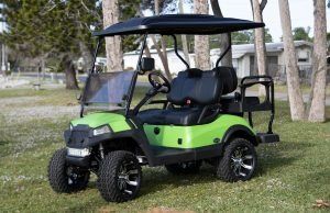 Lime green golf cart with black accents and canopy on grass.