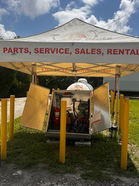 a tent reading “PARTS, SERVICE, SALES, RENTAL” with open rear doors