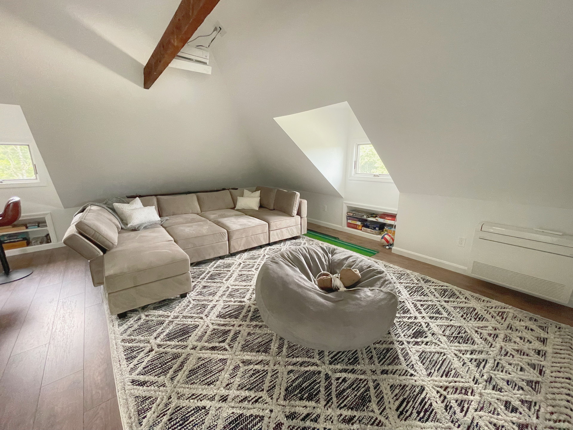 Interior remodeling. Depicted is a finished attic space that has been fully furnished. The area has full HVAC, new windows, and custom shelving.