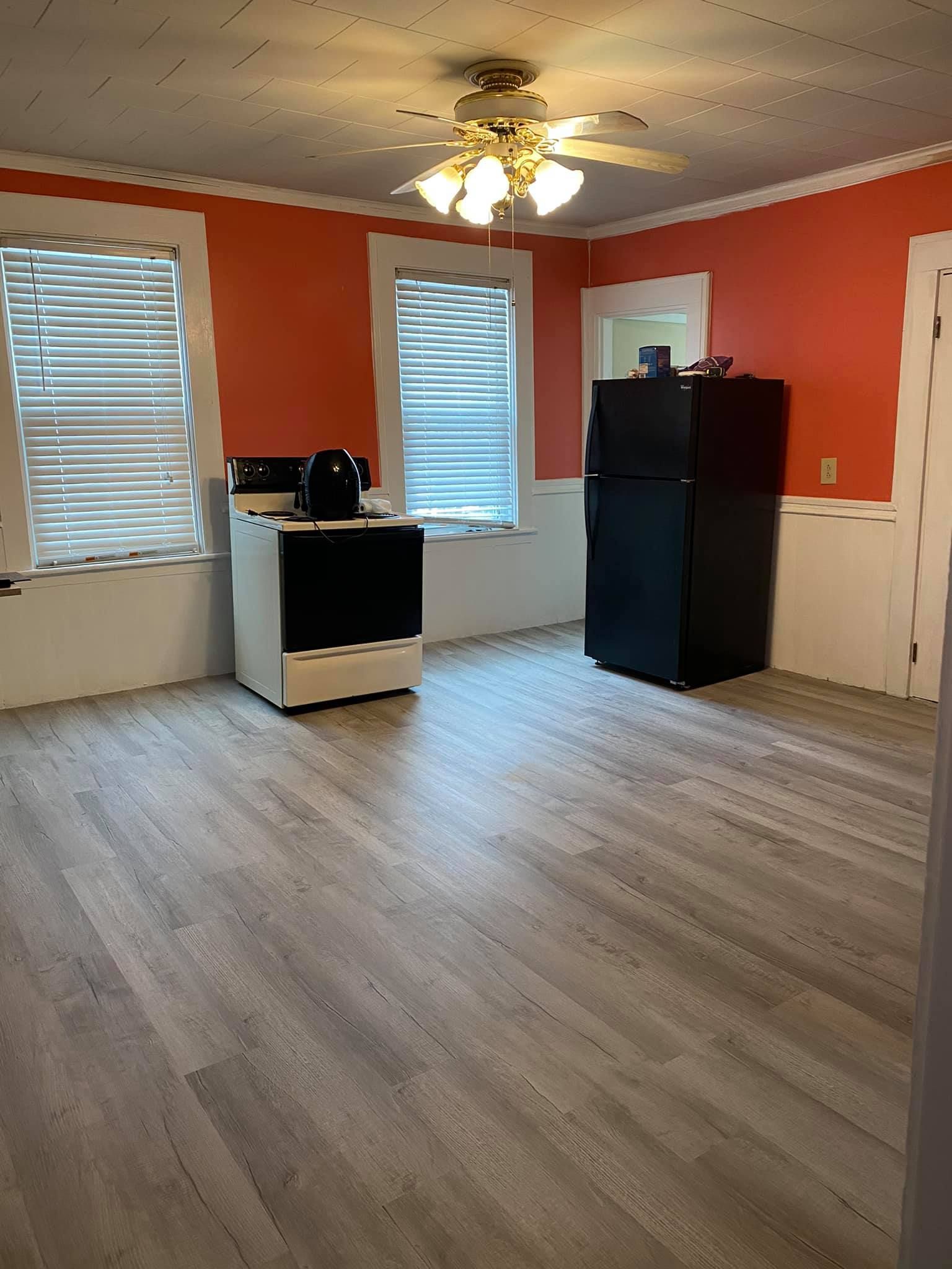 a kitchen with a stove , refrigerator , and ceiling fan .