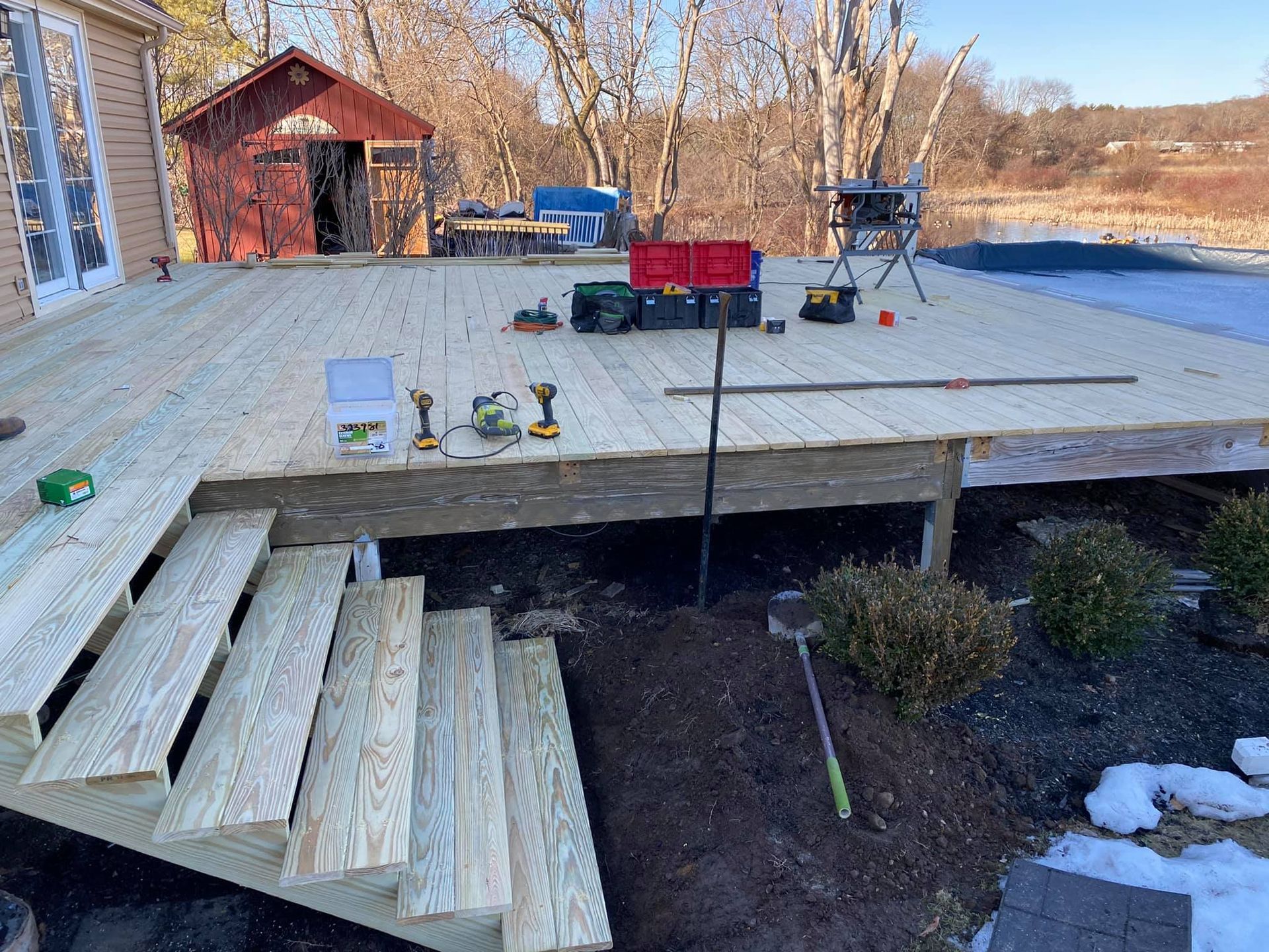 a wooden deck is being built in the backyard of a house .