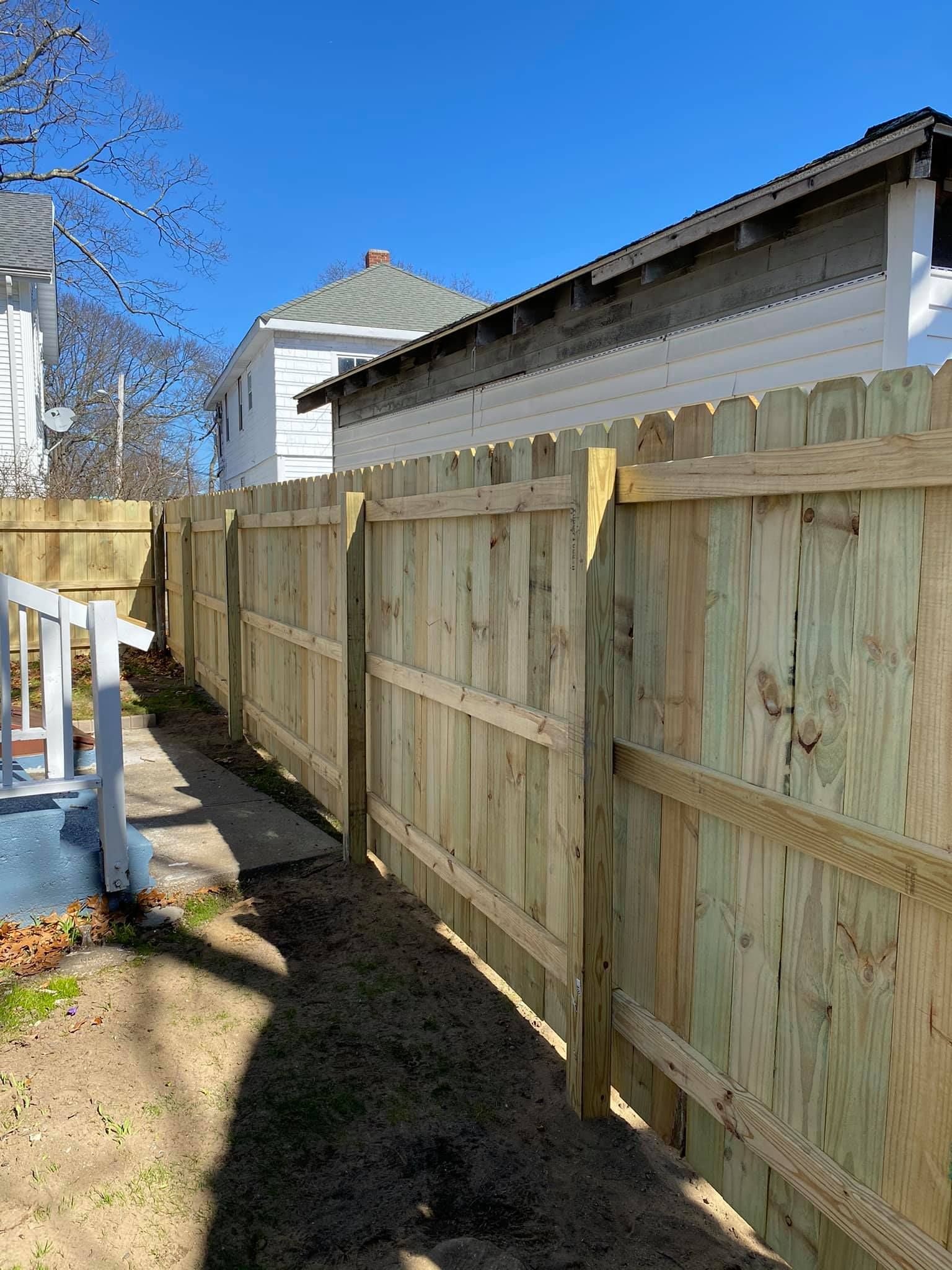 a wooden fence is in the backyard of a house .